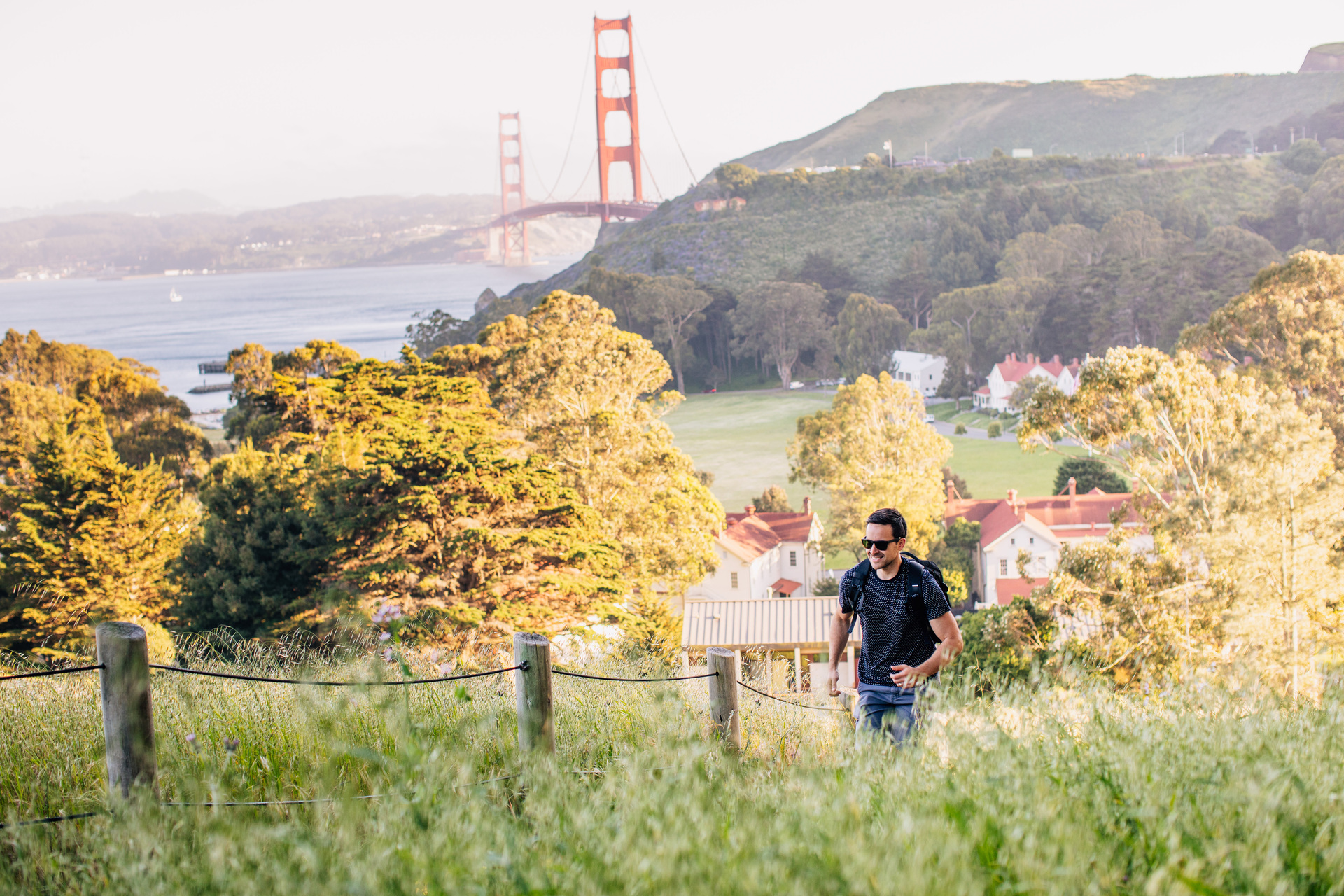 man hiking golden gate and property in background