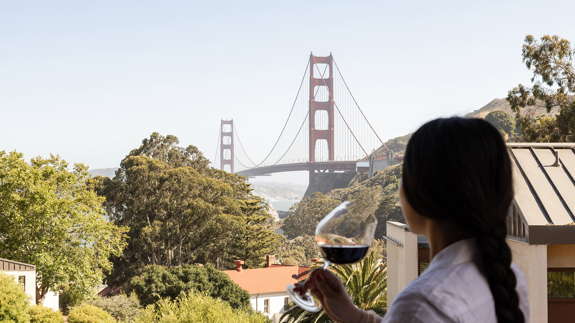 woman with glass of wine overlooking the golden gate bridge