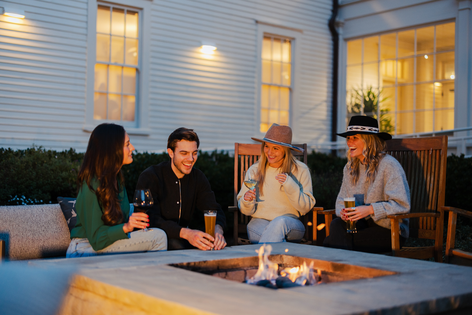 two couples sitting next to the firepit with drinks at cavallo point.